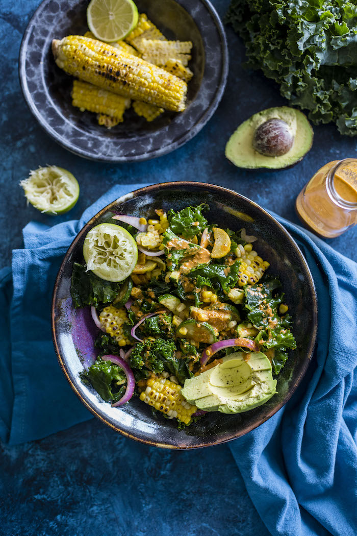 A hearty kale salad topped with grilled corn, red onions and a zesty chile lime dressing. It's the perfect side dish for all your summer BBQ's!