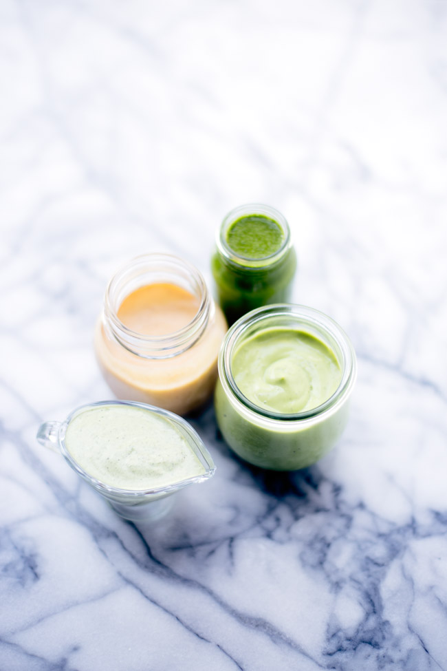 Brighten up your salad with four healthy salad dressing recipes! Garlic Basil, Herby Vegan Ranch, Avocado Cilantro, Citrus Maple Cayenne.