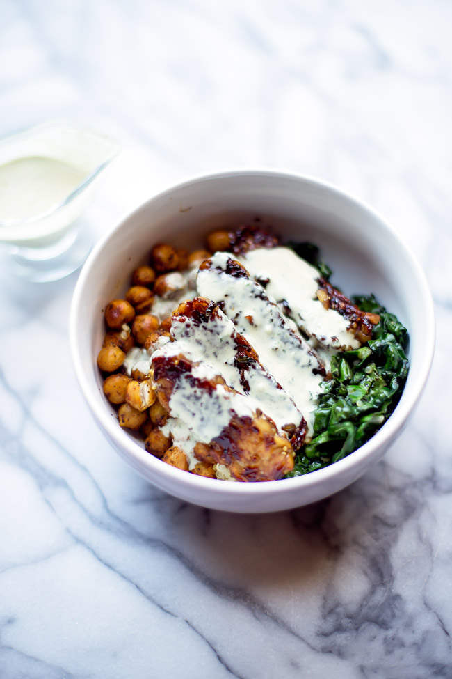 This hearty, satisfying bowl is packed with quinoa, kale, blackened tempeh, spiced chickpeas and is topped with a garlicky tahini sauce. 