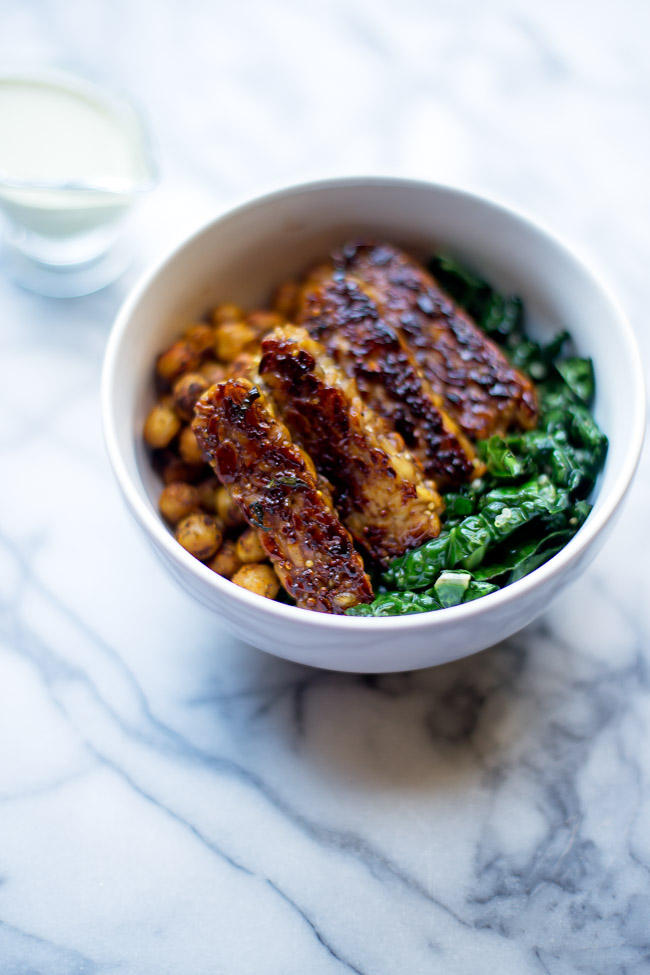 This hearty, satisfying bowl is packed with quinoa, kale, blackened tempeh, spiced chickpeas and is topped with a garlicky tahini sauce. 